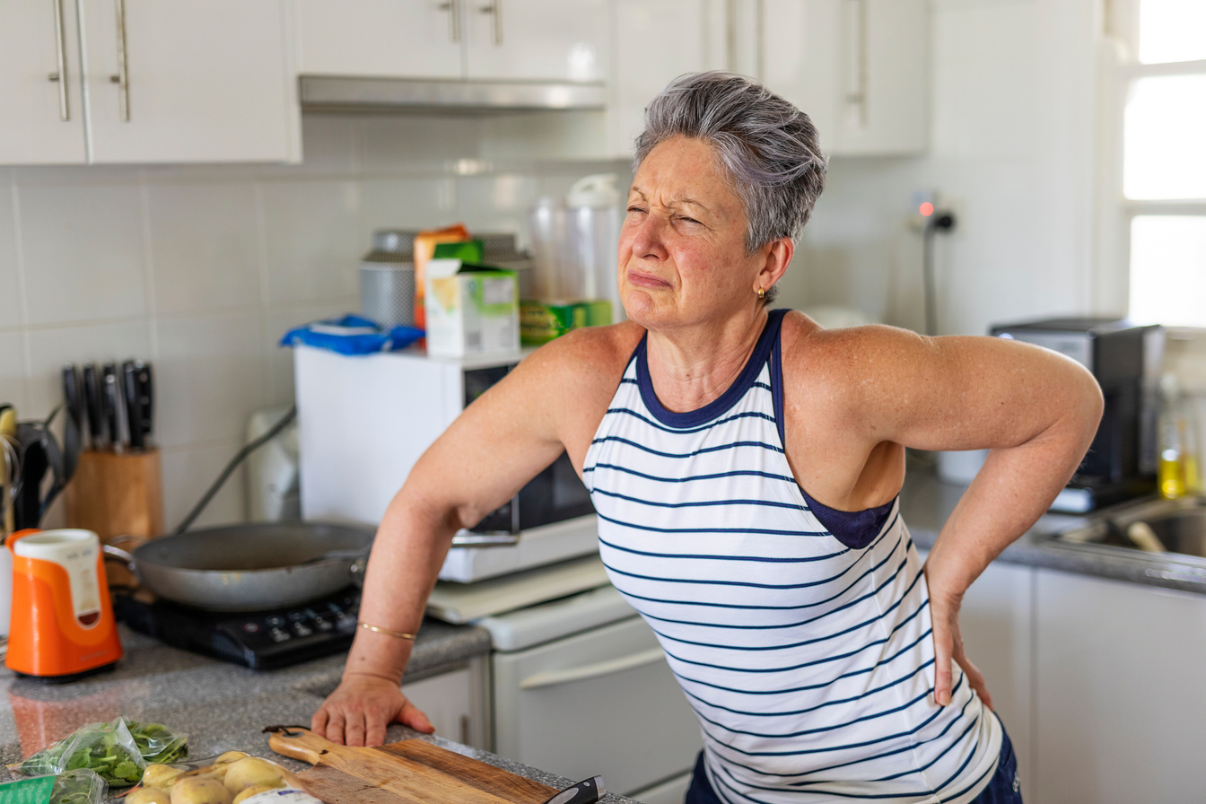 Senior Woman With Back Pain in the Kitchen